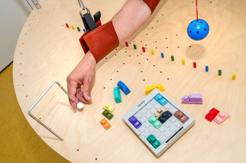 Koordinationsübungen der Hand auf einem Tisch mit unterschiedlichen ergotherapeutischen Übungen